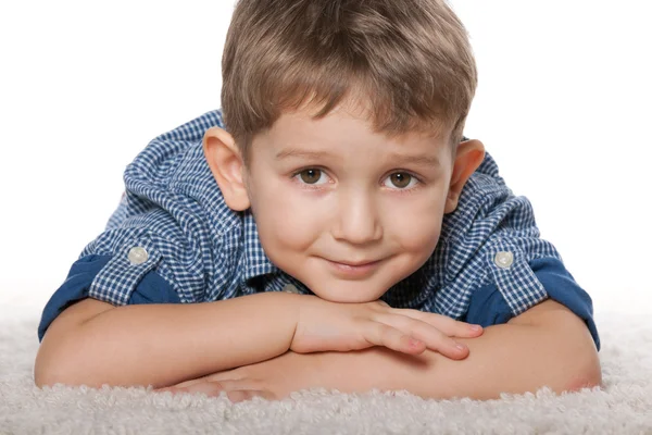 Nachdenklicher Junge auf dem weißen Teppich — Stockfoto