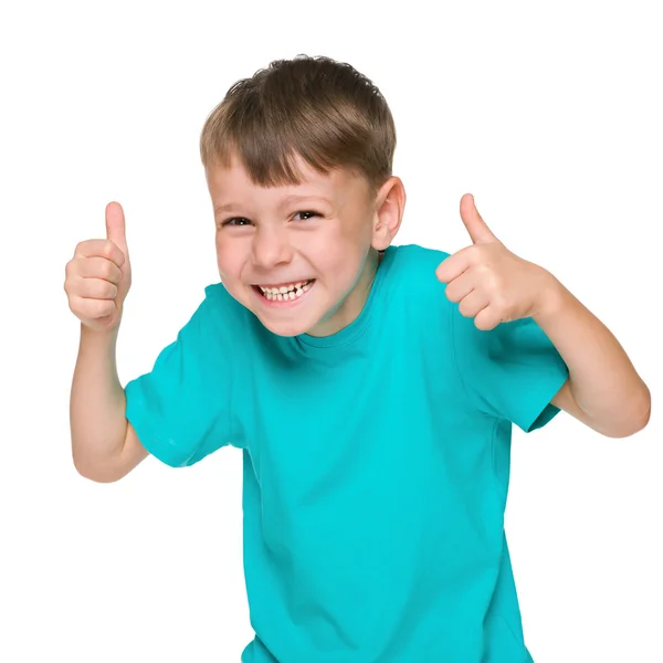 Смеющийся маленький мальчик держит большие пальцы вверх — стоковое фото