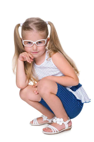 Little girl in glasses sits on the floor — Stock Photo, Image