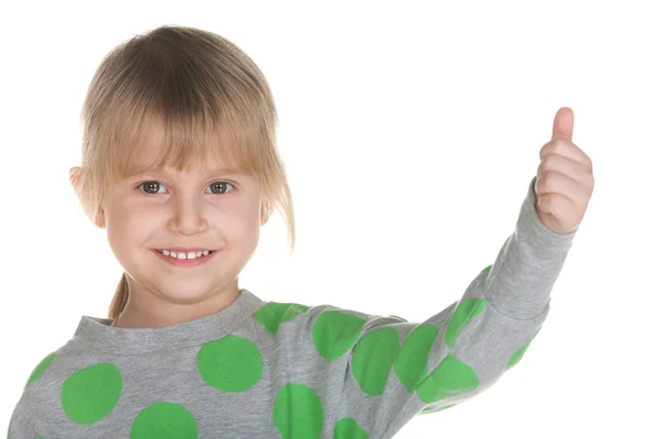 Sonriente niña sostiene su pulgar hacia arriba — Foto de Stock