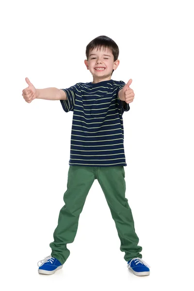 Jonge jongen in een groene broek houdt zijn duimen omhoog — Stockfoto