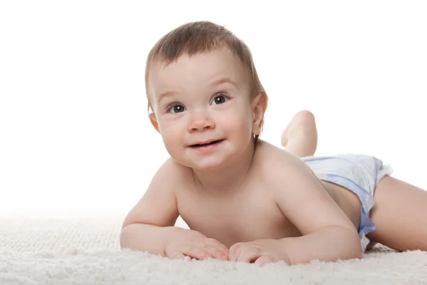 Schattige baby jongen liggen op het witte tapijt — Stockfoto