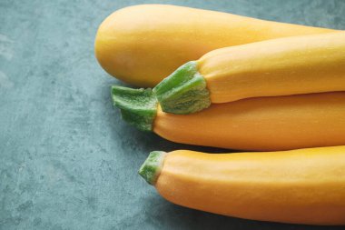 Mutfak masasında dört sarı kabak. Tamamen çiğ kabak.