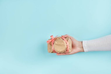 Kadın eli, el işi kağıdına sarılı bir kamera verir. Gizemli sürpriz, hediye.