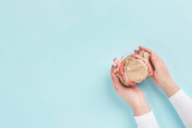 Kadın eli, el işi kağıdına sarılı bir kamera verir. Gizemli sürpriz, hediye.