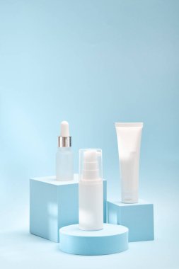 Geometrik podyumlarda üç kozmetik ürün modeli. Kozmetik sunumu için arkaplan