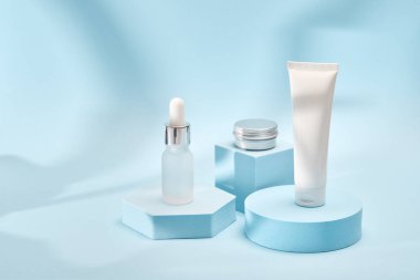 Geometrik podyumlarda üç kozmetik ürün modeli. Kozmetik sunumu için arkaplan