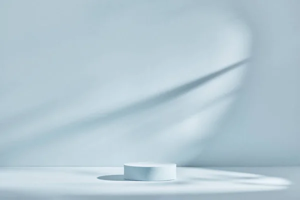 Gölgeli ve ışıklı ürün sunumu için mavi arkaplan. Boş podyum. Model.