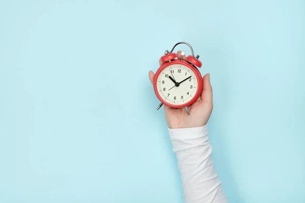 Reloj Despertador Rojo Mano Mujer Sobre Fondo Azul —  Fotos de Stock