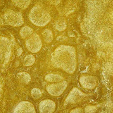 Altın sıvı. Süzülen altının benekli yüzeyi. Soyut ışıltılı arkaplan.