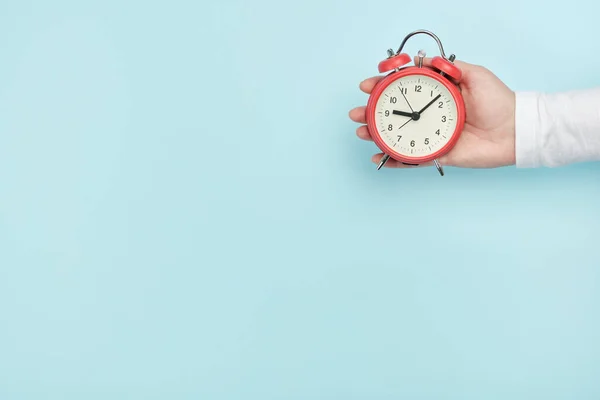 Reloj Despertador Rojo Mano Mujer Sobre Fondo Azul —  Fotos de Stock