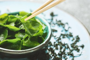 Sırılsıklam ve kurumuş wakame yosunu. Japon yemeği. Sağlıklı deniz ürünleri