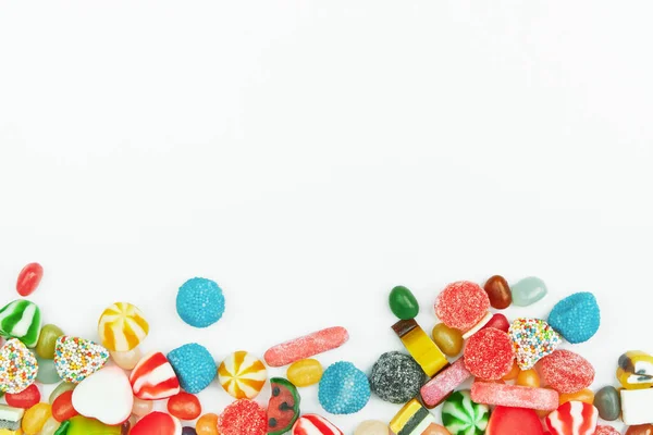 Beyaz arka planda çok renkli jelibon şekerler. Şenlikli çerçeve arkaplanı.
