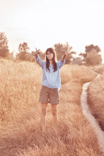 十几岁的女孩表现出一个岩石迹象 农村的草原 — 图库照片