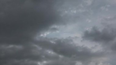 Gri gök gürültülü bulutlar parlak gündüz gökyüzünü engelliyor. Hızlı ve dramatik hareketler.