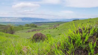 Bulutların zamanı, yeşil dağlar ve vadi manzaralı. Güneşli yaz havası. Ufuktaki kayalar ve dağlar.