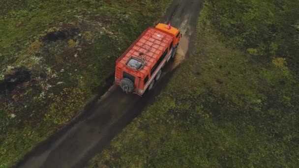 トラックは障害物を通って山道を運転している 空中展望 途中でバンプ バンプや水たまり 地上ではない風景 — ストック動画