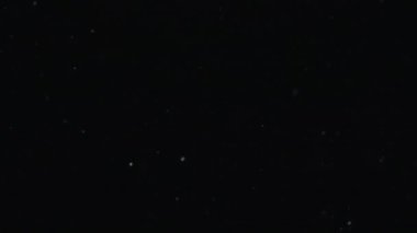 Siyah zemin üzerinde beyaz-gümüş parçacıkların havada asılı kalması. Bazı parçacıklar güzel bir bokeh içinde bulanıklaşıyor. Çeşitli karıştırma kiplerinde videolarınız için 4K arkaplan.