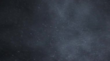 Siyah zemin üzerinde beyaz-gümüş parçacıkların havada asılı kalması. Bazı parçacıklar güzel bir bokeh içinde bulanıklaşıyor. Çeşitli karıştırma kiplerinde videolarınız için 4K arkaplan.