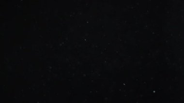Siyah zemin üzerinde beyaz-gümüş parçacıkların havada asılı kalması. Bazı parçacıklar güzel bir bokeh içinde bulanıklaşıyor. Çeşitli karıştırma kiplerinde videolarınız için 4K arkaplan.