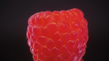 Süper makro ahududu. Videoyu 360 derece döndürdüm. Siyah ayna arka planında yavaş çekim.
