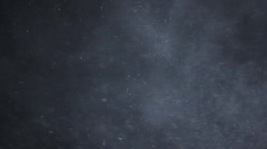 Siyah arka planda havada beyaz-gümüş parçacıkları var. Bazı parçacıklar güzel bir bokeh içinde bulanıklaşıyor. Çeşitli karıştırma kiplerinde videolarınız için 4K arkaplan.