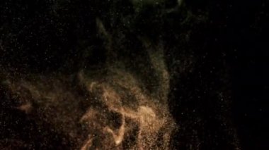 Siyah bir zeminde yüzen altın gibi parlak parçacıkların askıya alınması. Çeşitli karıştırma kiplerinde videolarınız için 4K arkaplan.
