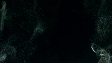 Siyah bir zeminde yüzen altın gibi parlak parçacıkların askıya alınması. Çeşitli karıştırma kiplerinde videolarınız için 4K arkaplan