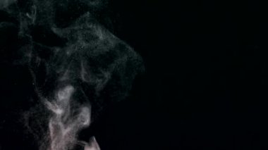 Siyah bir zeminde yüzen altın gibi parlak parçacıkların askıya alınması. Çeşitli karıştırma kiplerinde videolarınız için 4K arkaplan