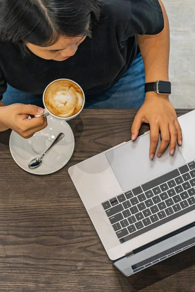 Vista superior de la foto de la mujer tomando café y el uso de ordenador portátil — Foto de Stock