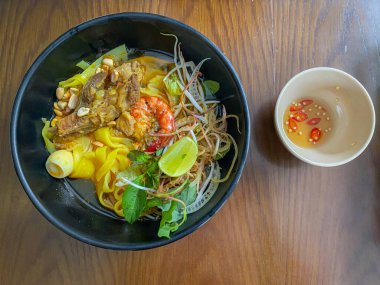 Vietnam pilavlı erişte kasesinin üstünde Mi Quang resmi var.