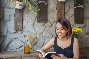 Kitap okuyan Asyalı kadın