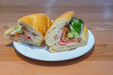 Yarım yamalak Vietnamlı domuz sandviçi, beyaz tabakta banh mi