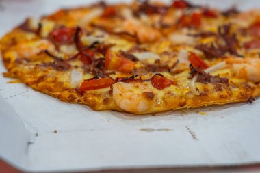 Karides, soğan ve dolmalık biberli deniz ürünleri pizzası.