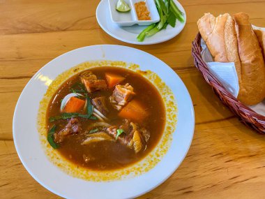 Bo Kho baget ekmeğiyle servis edilen leziz biftek buğulama.