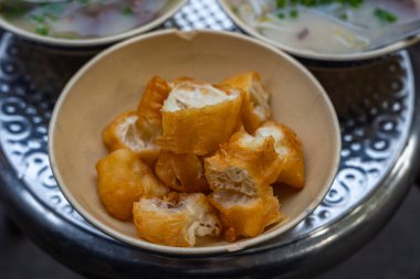 Bir kase kızarmış ekmek ya da domuz etiyle servis edilen hamur çubukları. 