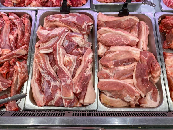 Carne di maiale cruda in vendita presso la bancarella del macellaio nel supermercato — Foto Stock