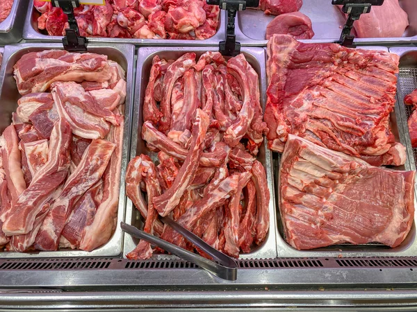 Carne di maiale cruda in vendita presso la bancarella del macellaio nel supermercato — Foto Stock