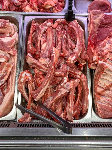 Foto verticale di carne di maiale cruda in vendita presso la bancarella del macellaio — Foto Stock