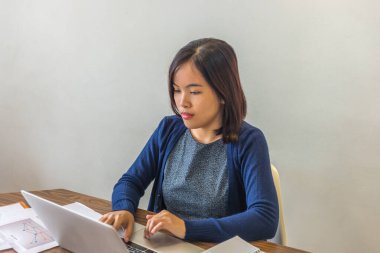 Asyalı serbest çalışan ev bilgisayarında çalışıyor.