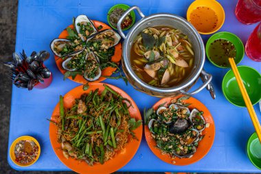 Gece pazarındaki Vietnam sokak yemekleri. Izgara midye ve midye.