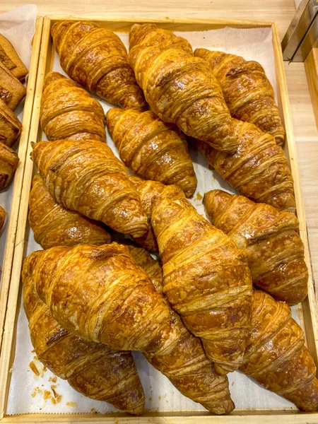Függőleges fotó sok francia croissant a fa tálcán — Stock Fotó
