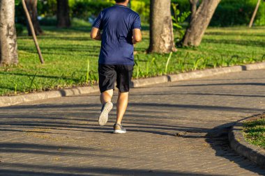 Parkta koşan sporcu adam, sağlıklı yaşam tarzı konsepti.