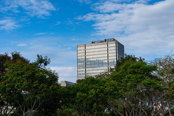 Office building and green space on blue sky background