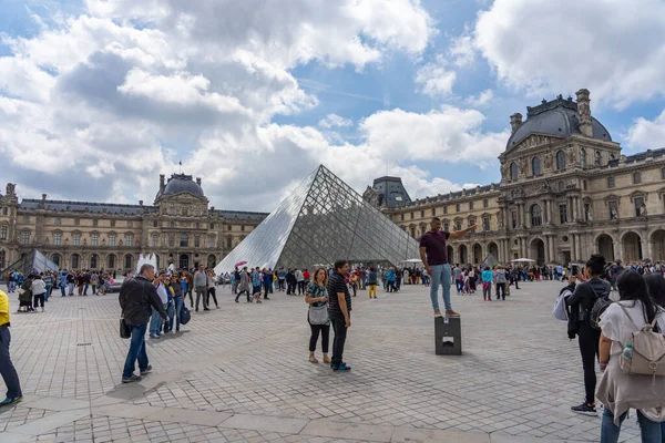 19 junio 2019 - PARÍS, FRANCIA: Multitud de turistas tomando fotos con la Pirámide del Louvre, París — Foto de Stock