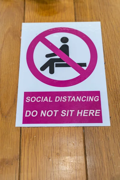 Foto vertical del cartel de no sentarse en el fondo del banco de madera — Foto de Stock