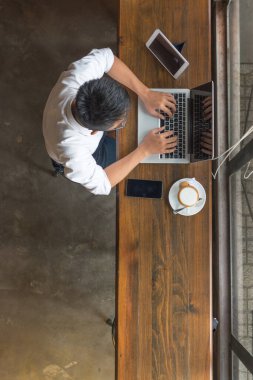 Laptop, akıllı telefon ve tablet kullanan bir işadamı
