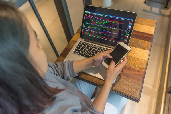 Geschäftsfrau nutzt Telefon zum Handel an der Börse — Stockfoto