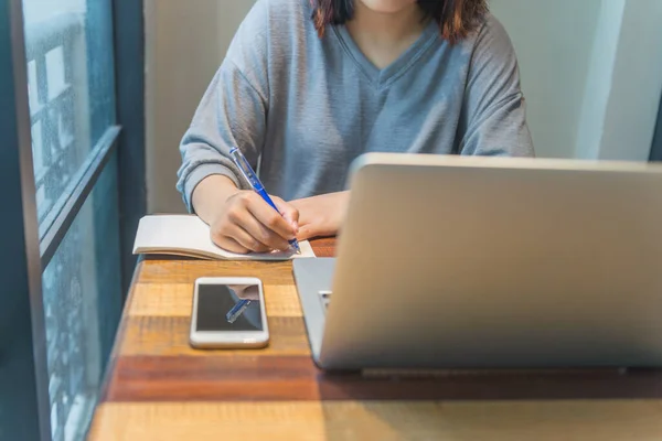 Joven estudiante asiático escribiendo en la nota — Foto de Stock