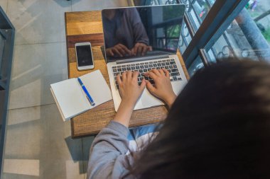 Dizüstü bilgisayarda çalışan Asyalı genç serbest yazar.